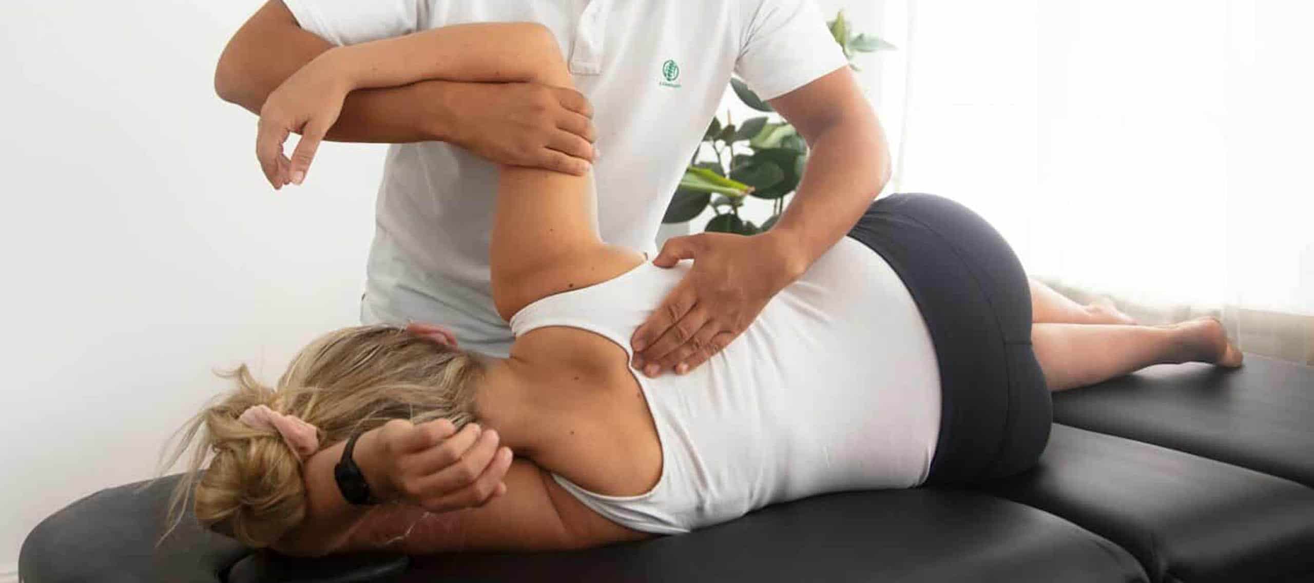 Chiropractic Adjustment for Back Pain Relief Chiropractor performing back adjustment on a patient lying face down.